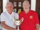 The image shows Alan Campbell, Club President (Red), presenting the trophy to Club Captain Dave Greenland (White)